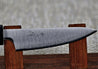 Akifusa's Aogami Super 80mm Paring knife on a red wood stand, close up showing the blade finish and engraving