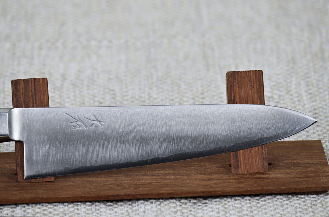 Ohishi VG5 Migaki 180mm Gyuto (Chef) Japanese kitchen knife on redwood stand, close up of the blade and engraving