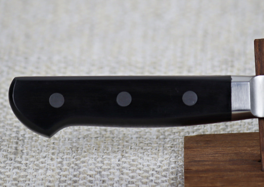 Ohishi VG5 Migaki 180mm Gyuto (Chef) Japanese kitchen knife on red wood stand, close up of the triple riveted black Pakka wood handle and integral bolster