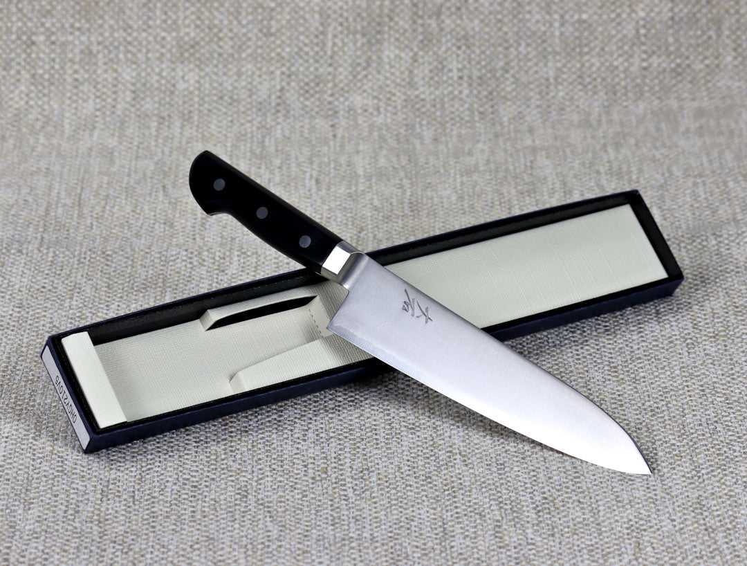 Ohishi VG5 Migaki 210mm Gyuto (Chef) Japanese kitchen knife, resting at an angle across its packaging