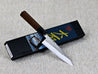 Ohishi SD 135mm Petty Utility Japanese kitchen knife with migaki(polished/tsuchime(hammered) finish and traditional Ebony handle resting on an angle across it packaging 