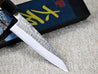 Ohishi SD 135mm Petty Utility Japanese kitchen knife with migaki(polished/tsuchime(hammered) finish and traditional Ebony handle close up of blade and finish whilst resting on its packaging