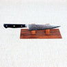 Ohishi Classic Powder Metal Damascus 150mm Petty (Utility) Japanese kitchen knife on a red wood stand displaying the "Floating Ink" finish on the blade and the mosaic pin in the handle