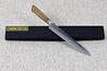 TadafusaAogami2 Nashiji Sujihiki240mm lying at an angle across packaging, handle to top left
